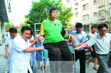 　坐上特制的轮椅，王峰军被众人簇拥着，一路推进病房楼。 首席记者杜小伟摄影