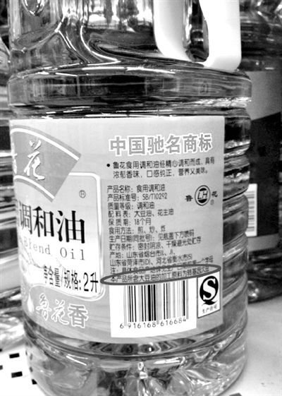 昨日，宣武门一超市内的两款调和油，均用小字标注转基因字样（圆圈内）。新京报记者邓琦摄