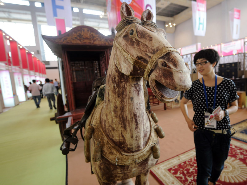 6月8日，一家家具厂推出的中国古代马车吸引了一名参观者。


