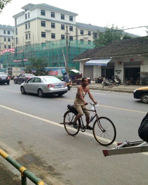 男子闹市区裸身穿胸罩骑车唱歌 被称胸罩男(