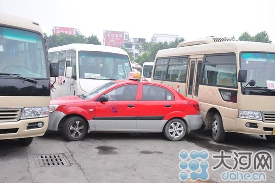 信阳出租车和中巴车为抢乘客顶牛车站出口被