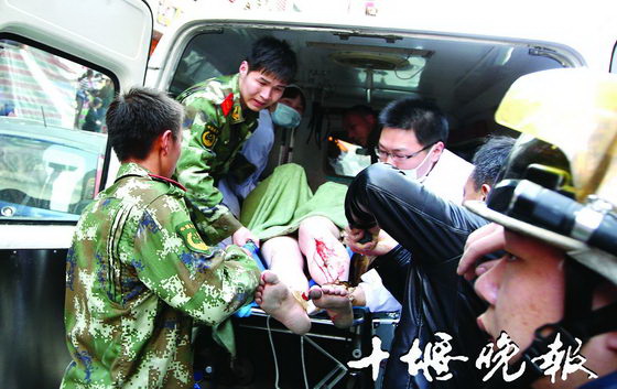 救援人员将伤者抬上救护车
