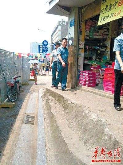 长沙市雨花亭小学校门附近，一栋私房将人行横道截断，剩下一条约三十厘米的“窄路”。记者李琪摄