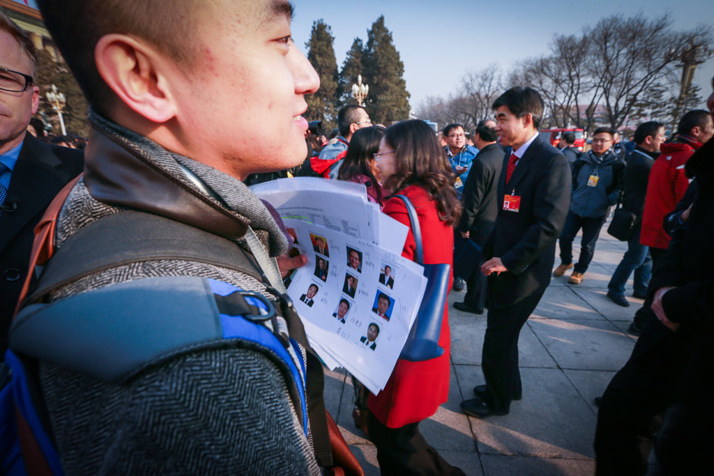 2015两会:记者手持照片 茫茫人海找寻采访对象