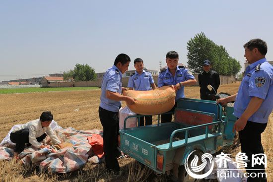 图3：民警将装好的麦子装到三轮车上