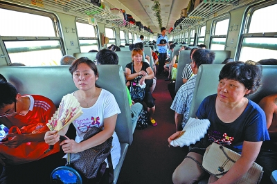 绿皮火车内无空调,高温接近50℃,乘客只能自己摇扇子.