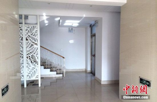 进办公楼得在大门口换拖鞋 办公楼正面的围墙是白色的,应该是石头垒成后进行了外部修饰,上面安置了高半米、枪头形的铁护栏。侧面是红色砖墙,砖墙上面拉上了铁丝网。 大门插着,记者拨开门闩,进入院子。院子不同于门卫的水泥路面,而是使用石块铺成。院子很大,有几百平方米。