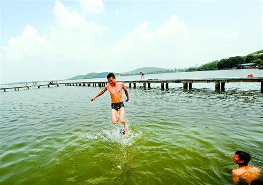 图为：被同伴抛出水面后，一名市民东湖里练习“水上漂”。（记者 张朋 摄）