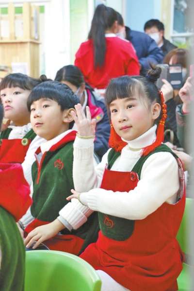 小朋友举手回答老师提问 “锣鼓铿锵敲起来,喜迎佳节乐开怀,今天说段三句半——请看! 快乐幸福的大五班,三年生活乐无边,唱歌跳舞做游戏——神仙!” 2014年最后一天,开封市金明幼儿园大五班的小朋友们表演的这段三句半节目,引得家长捧腹大笑。