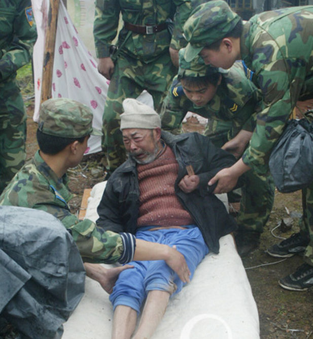 汶川抗震救灾,5月13日,空军某部官兵在废墟里救出一名老人.