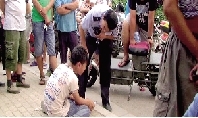郑州一男孩当街摸女子臀部 被抓后跪地道歉(图)