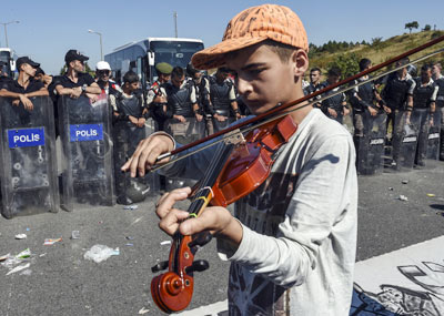13岁难民警察盾牌阵前拉小提琴