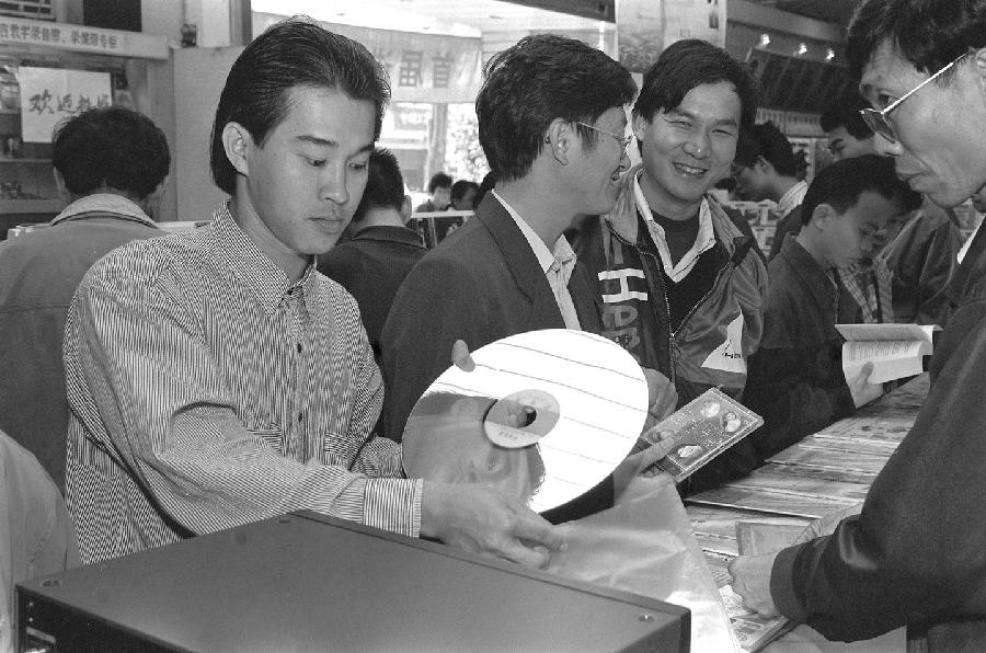 从腰挎BP机到手持“大哥大”，再到“苹果”电子产品引来“果粉”无数；从邓丽君、费翔、崔健一个个文艺偶像红遍大江南北，到真人选秀节目你方唱罢我登场，各类综艺节目精彩纷呈；到如今怀旧复古正当红，环保低碳最流行……图为1996年1月，顾客在海南省新华书店购买影碟。当时，CD唱片、影碟、录音带、录相带等音像作品销售十分火爆。