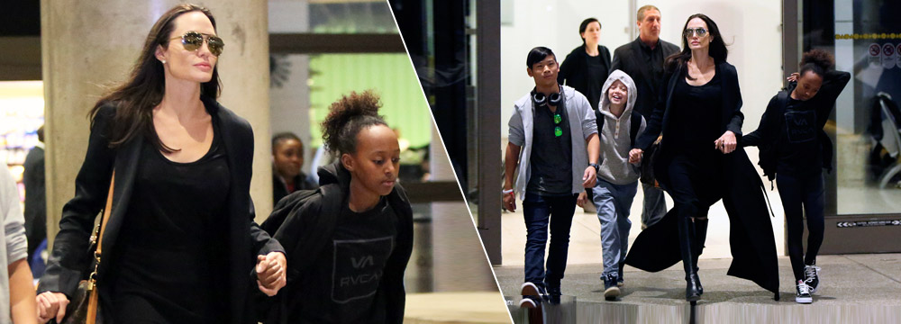 机场变T台！朱莉带三娃现身 长风衣展女王气场 
