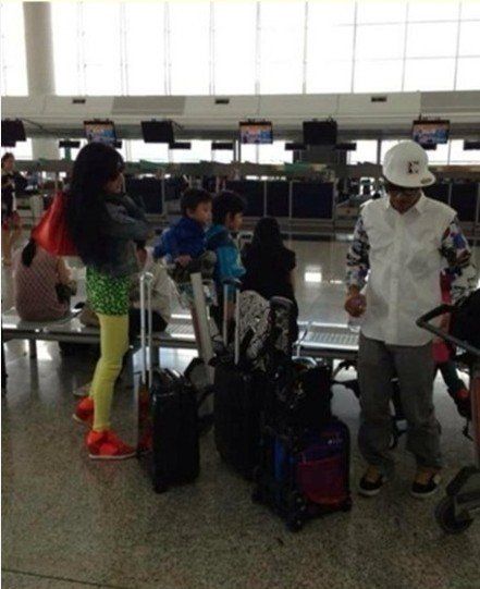 张柏芝与子现身机场 兄弟俩坐行李车可爱