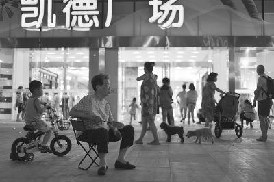 昨晚，武胜路一商场门前蹭凉的市民。记者胡伟鸣 摄 