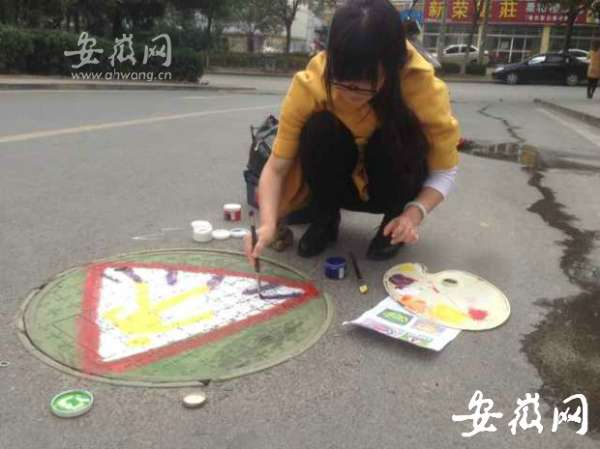 合肥经开区志愿者窨井盖上涂鸦 倡导文明出行