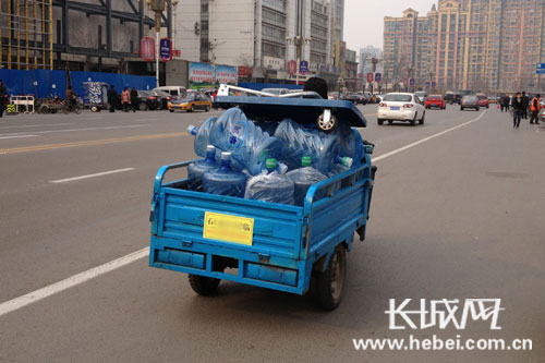 送水公司的蓝色电动三轮车. 长城网 李丹丹 摄