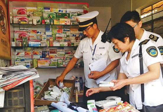 执法人员一丝不苟地查看黑诊所里的药物。记者 丁明 摄