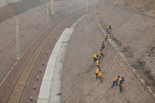 攀岩清除路堑护坡上的杂物 (新华社记者 梁鹏摄)