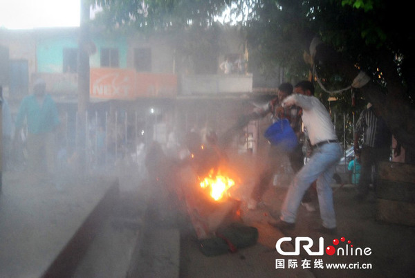 　　当地时间2014年4月29日，印度Sultanpur，印度大选一场电视直播辩论会发生意外，一名现场观众点火自焚并将火势引导一名政客身上，两人都在地上挣扎。图片来源：STR/CFP