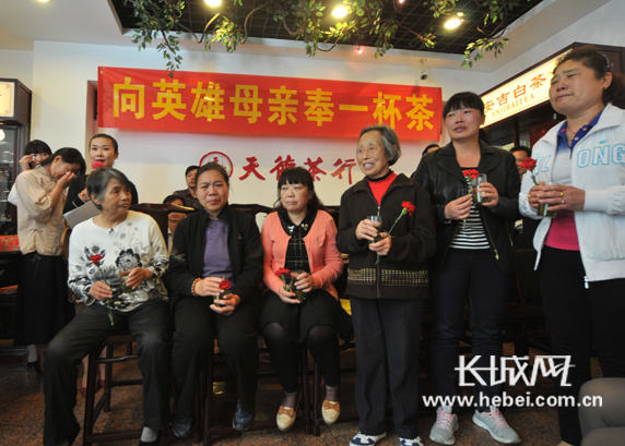 　　英雄母亲手捧香茶和鲜花激动得泪流满面。长城网记者 孙阳 摄