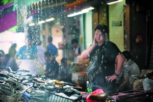 ▲昨日在海珠南路，中午一点左右，广州突降大雨，一名没带伞的市民被逼到路边的遮雨棚躲雨。　　信息时报见习记者　　陈引 摄