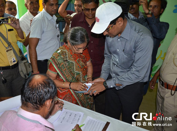 　　当地时间2014年4月30日，印度乌恩贾，印度人民党总理候选人纳伦德拉·莫迪的夫人贾苏达本参加大选投票。在投票前，她还去了寺庙为莫迪祈祷。图片来源：STR/CFP
