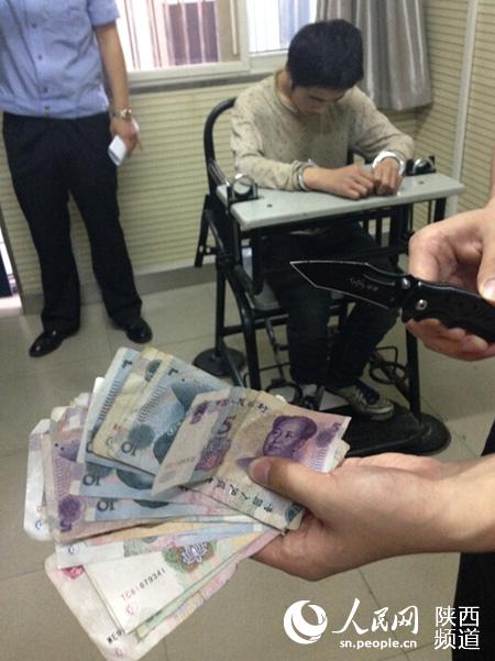 嫌疑人抢劫使用的刀具和抢来的钱 庞铭/摄