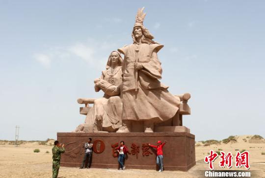 图为游客正在“巨人之家”雕塑下拍照留念。　李江帆　摄