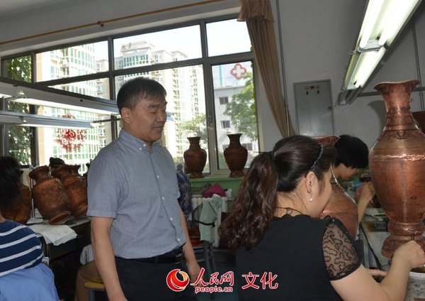 景泰蓝大师钟连盛指导学徒工艺制作（人民网记者许心怡 摄）