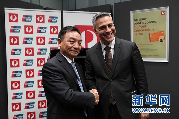 中国银联总裁时文朝与澳大利亚邮政局首席执行官法胡在签约仪式上握手