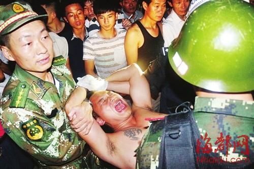 李某被控制后挣扎大喊，被民警抬出，押上警车