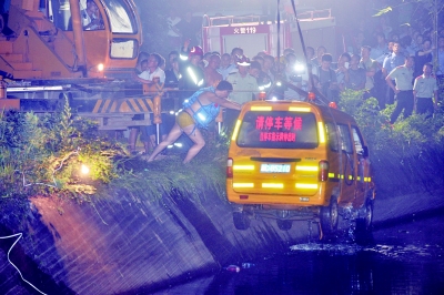 　　7月11日凌晨3点整，长沙岳麓区含浦街道干子村，失事的校车被吊出水面。 记者 田超 摄