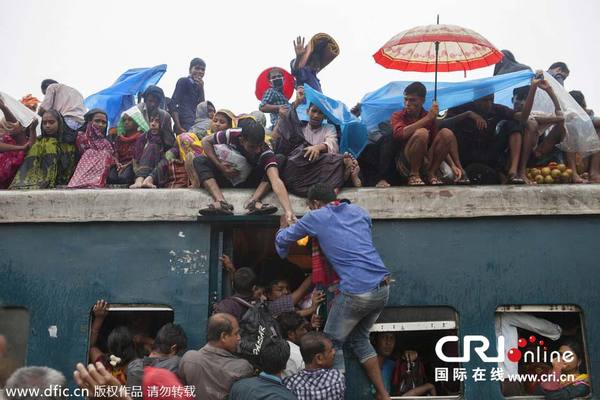 　　当地时间2014年7月27日，孟加拉国达卡，民众爬上拥挤的火车，准备回家过开斋节，人潮爆满，火车里外上下都是人。图片来源：Probal Rashid/东方IC