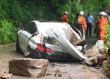 7月31日,崇州三郎镇前往九龙沟路上,巨石砸中宝马车,消防人员赶到现场救援。