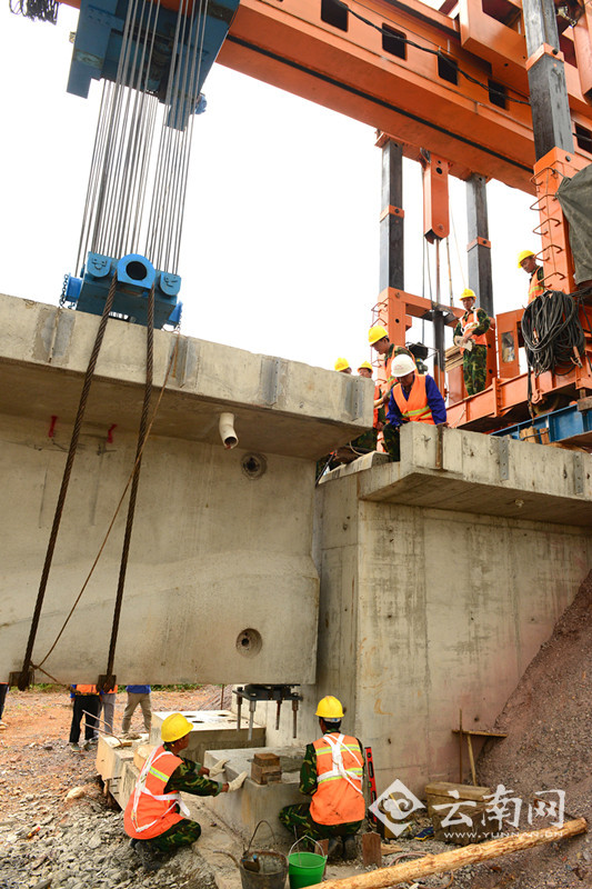 T型梁纵向推进横移到位后，施工人员在精确定位。（通讯员 汪建云 摄影）