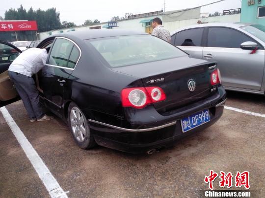 维修厂把拆下的机件全放在车后备箱，致车尾部严重下沉　董飞　摄