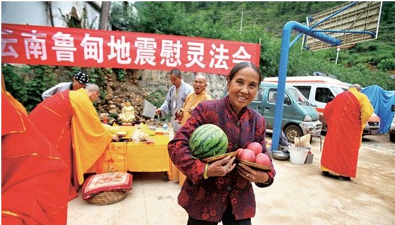 受灾群众高兴地带着用来做法事的水果回家,希望与家人吃后能平平安安,健健康康。