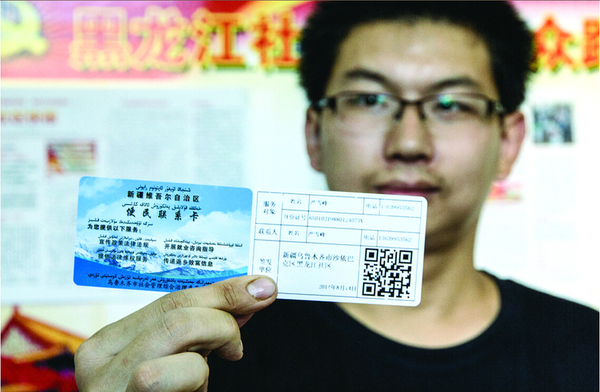 乌市黑龙江社区的工作人员在介绍便民联系卡的内容。