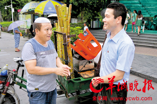艾山艾力(右)在与小贩交谈 实习生 吴梓鸿 羊城晚报记者 周巍 摄