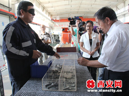 　　一线工人正在表演“蒙眼摸螺丝”