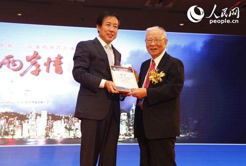 中央政府驻港联络办副主任杨建平(左)给许历农上将颁发两岸关系杰出贡献奖。(人民网记者 袁悦摄影)