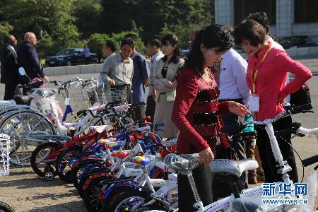 9月22日，在朝鲜平壤，人们在自行车展台前参观。