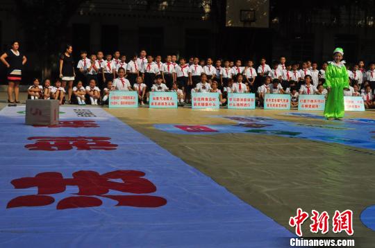 9月24日，广西柳州市岩村路小学生在下巨型“法制棋”。周潇男　摄