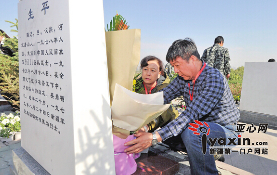 9月27日，在烈士陵园，烈士亲属在墓碑前摆放鲜花。