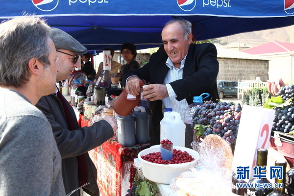图为阿列尼村民让游人品尝自酿美酒。新华社记者魏大方摄