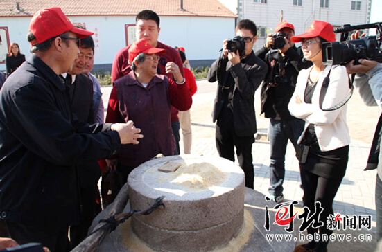 大爷大妈看到磨盘后为晚辈讲解他们小时候的故事