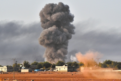 13日，被“伊斯兰国”围攻的叙利亚边境重镇艾因阿拉伯（库尔德人称科巴尼）遭到多国联盟空袭后升起浓烟。
