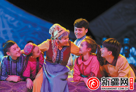歌舞剧《情暖天山》中，迪里拜尔饰演的“妈妈”帕丽达正在哄孩子们睡觉。（资料图片）